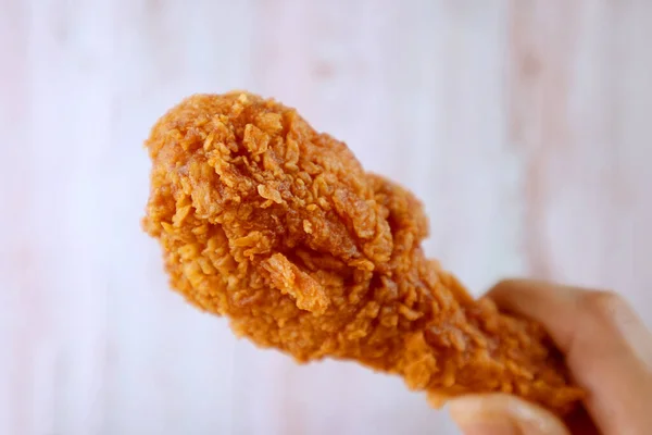 Closeup Crunchy Fried Chicken Drumstick Hand Blurry Wooden Wall Background — Stock Photo, Image