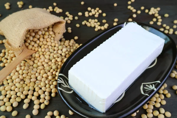 Plate of Soft Tofu Bean Curd with Dried Soybeans Scattered from Burlap Bag in the Backdrop