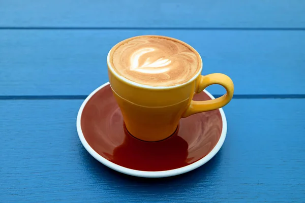 Cappuccino Koffie Geel Bruin Kopje Geïsoleerd Blauwe Houten Tafel — Stockfoto