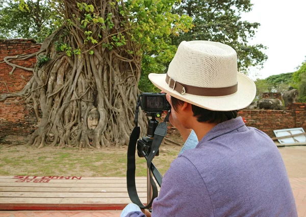 泰国阿尤塔亚Wat Mahathat寺废墟中的菩提树根中著名古佛像头像照片的游客 — 图库照片