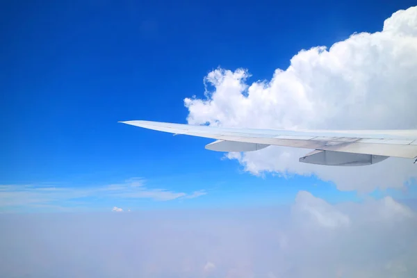 飛行中に飛行機の窓から見える飛行機の翼を持つ鮮やかな青い空と純粋な白い雲 — ストック写真