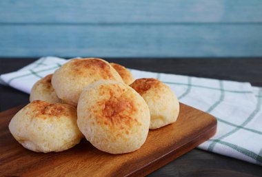 Tahta ekmek tahtasında Pao de Queijo adlı leziz Brezilya peynirli ekmek yığını.