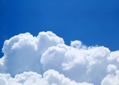 Güzel pofuduk beyaz kümülüs bulutları canlı mavi güneşli gökyüzünde süzülüyor