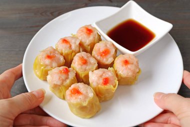 Elle Karides ve Domuz Doldurulmuş Çin Buharlı Hamur Püresi veya Ahşap Masaya Shumai