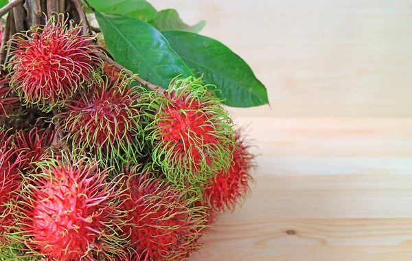 Banda Świeżych Dojrzałych Owoców Rambutan Izolowanych Drewnianym Tle — Zdjęcie stockowe