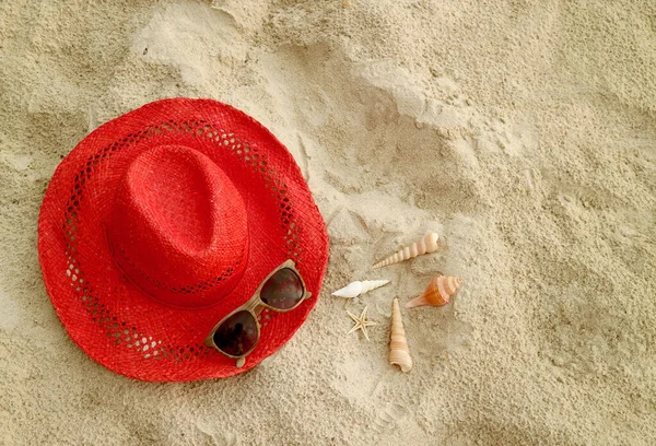 Red Straw Hat Sunglasses Sandy Beach Tiny Seashells — Zdjęcie stockowe