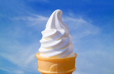Delectable Vanilla Soft Serve Ice Cream Cone on Sunny Blue Sky Background