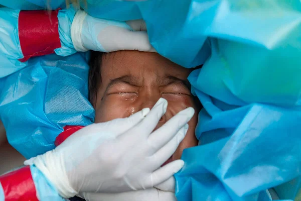 CHIANG MAI, THAILAND - Ban Pamuad Okulu 'nda hızlı bir antijen testi için bir sağlık çalışanı bir öğrenciden burun örneği alır. Tayland, 5-11 yaşlarındaki çocukları Ban Pamuad Okulu 'nda aşılamaya başladı.