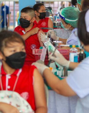 CHIANG MAI, THAILAND - 07 Mart 2022: Bir çocuk aşı kampanyası sırasında Pfizer-BioNTech COVID-19 aşısını (Comirnaty) aldı. Tayland, Baan Sankamphaeng Okulu 'nda 5-11 yaşlarındaki çocuklara aşı yapıyor..