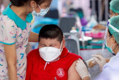 CHIANG MAI, THAILAND - 07 Mart 2022: Bir çocuk aşı kampanyası sırasında Pfizer-BioNTech COVID-19 aşısını (Comirnaty) aldı. Tayland, Baan Sankamphaeng Okulu 'nda 5-11 yaş arası çocukları aşılıyor..