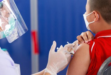 CHIANG MAI, THAILAND - 07 Mart 2022: Bir çocuk aşı kampanyası sırasında Pfizer-BioNTech COVID-19 aşısını (Comirnaty) aldı. Tayland, Baan Sankamphaeng Okulu 'nda 5-11 yaş arası çocukları aşılıyor..