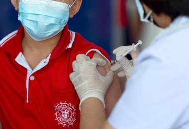 CHIANG MAI, THAILAND - 07 Mart 2022: Bir çocuk aşı kampanyası sırasında Pfizer-BioNTech COVID-19 aşısını (Comirnaty) aldı. Tayland, Baan Sankamphaeng Okulu 'nda 5-11 yaş arası çocukları aşılıyor..