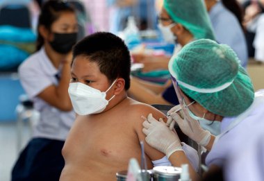 CHIANG MAI, THAILAND - 07 Mart 2022: Bir çocuk aşı kampanyası sırasında Pfizer-BioNTech COVID-19 aşısını (Comirnaty) aldı. Tayland, Baan Sankamphaeng Okulu 'nda 5-11 yaş arası çocukları aşılıyor..
