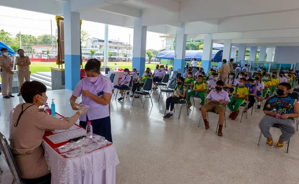 CHIANG MAI, THAILAND - 07 Mart 2022: öğretmenler aşıdan sonra 5-11 yaşlarındaki çocukları kontrol ediyorlar. Pfizer-BioNTech COVID-19 (Comirnaty) aşı kampanyası sırasında. Tayland, Baan Sankamphaeng Okulu 'nda covid-19' a karşı çocukları aşılıyor..