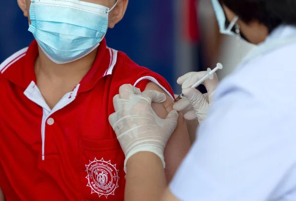CHIANG MAI, THAILAND - 07 Mart 2022: Bir çocuk aşı kampanyası sırasında Pfizer-BioNTech COVID-19 aşısını (Comirnaty) aldı. Tayland, Baan Sankamphaeng Okulu 'nda 5-11 yaş arası çocukları aşılıyor..