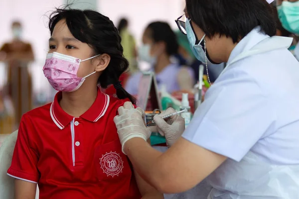 CHIANG MAI, THAILAND - 07 Mart 2022: Bir kız aşı kampanyası sırasında Pfizer-BioNTech COVID-19 aşısını (Comirnaty) aldı. Tayland, Baan Sankamphaeng Okulu 'nda 5-11 yaş arası çocukları aşılıyor..