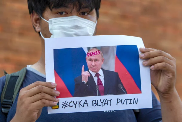 CHIANG MAI, THAILAND - Mart 06 2022: (EDITOR 'un Notu; İMAGE KONUŞMASI PROFANITY) Tayland aktivisti, Rusya' nın Tha Phae Kapısı 'ndaki Ukrayna işgaline karşı barışçıl gösterisinde Rus başkan Vladimir Putin' e karşı bir pankart tutuyor.
