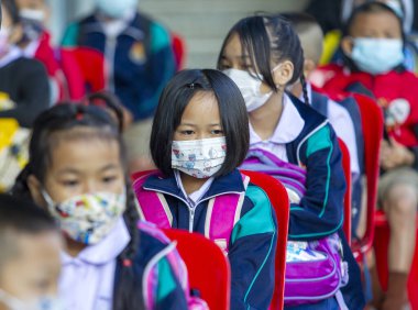 CHIANG MAI, THAILAND - 7 Şubat 2022: Yüz maskesi takan öğrenciler, Ban Pamuad Okulu 'ndaki hızlı bir antijen testi için geniz örneği almayı bekliyor. Tayland 5-11 yaşlarındaki çocukları aşılamaya başladı..