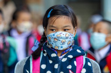 CHIANG MAI, THAILAND - 7 Şubat 2022: Yüz maskesi takan bir öğrenci, Ban Pamuad Okulu 'nda hızlı bir antijen testi için burun örneği alıyor. Tayland 5-11 yaşlarındaki çocukları aşılamaya başladı..