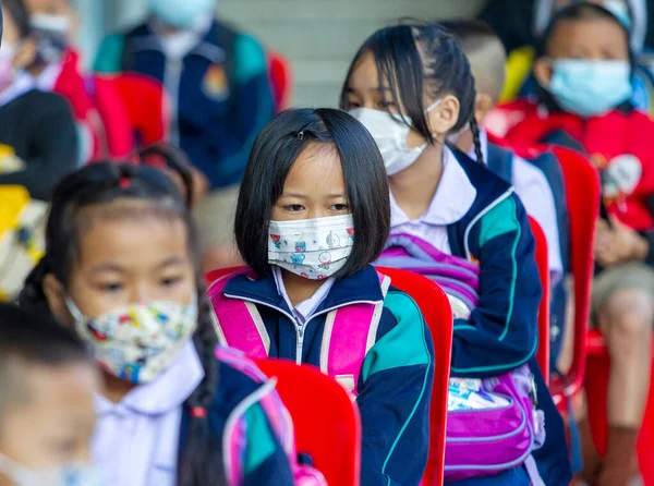 CHIANG MAI, THAILAND - 7 Şubat 2022: Yüz maskesi takan öğrenciler, Ban Pamuad Okulu 'ndaki hızlı bir antijen testi için geniz örneği almayı bekliyor. Tayland 5-11 yaşlarındaki çocukları aşılamaya başladı..