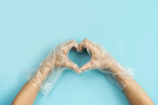 Рука Носить Одноразовые Пластиковые Перчатки Делает Форму Сердца Изолированы Цветном — стоковое фото