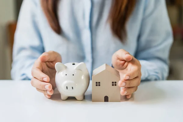 Young Woman Hands Protecting Miniature House Piggy Bank — Stockfoto