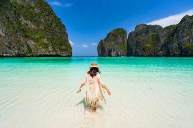 Genç bayan gezgin Krabi, Tayland 'daki Maya Körfezi' nde güzel tropikal beyaz kumsalda dinleniyor ve eğleniyor.