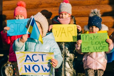 Genç vatanseverler, çocuk eylemciler. Ukraynalı küçük kızlar savaşı durdurmak istiyor. Yazılı pankartı yükseltin. Ukrayna 'daki savaşı durdurun.