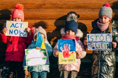 Genç vatanseverler, çocuk eylemciler. Ukraynalı küçük kızlar savaşı durdurmak istiyor. Yazılı pankartı yükseltin. Ukrayna 'daki savaşı durdurun.