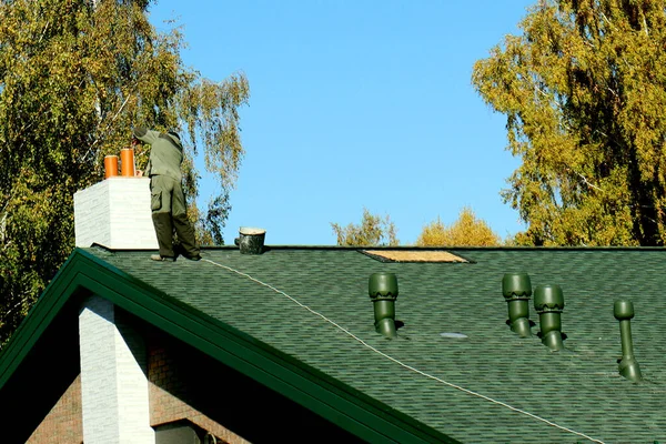 시골 집을 짓는 것. 파이프와 환기 시스템의 설치. 건축 업자는 집 지붕 위에서 작업을 한다 — 스톡 사진