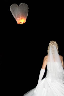 Sarışın gelin ve gece gökyüzünde beyaz Çin feneri. Siyah arka planda bayan görünümü. Gelin modası