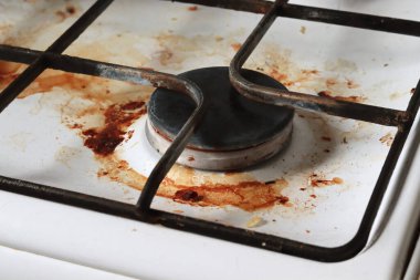 Gıda enkazı ve yağ lekeleriyle dolu kirli gaz ocağı. Yağ lekeli kirli bir gaz ocağı, eski yağ lekeleri, kızarma lekeleri ve yağ lekeleri..