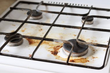 Gıda enkazı ve yağ lekeleriyle dolu kirli gaz ocağı. Yağ lekeli kirli bir gaz ocağı, eski yağ lekeleri, kızarma lekeleri ve yağ lekeleri..