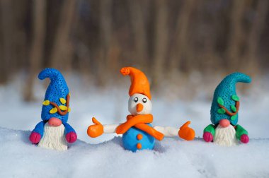 Kardan adam ve karlı ormanda bir cüce figürü. Yeni yıl havası..