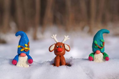 Kış ormanında bir geyik ve iki cüce figürü..