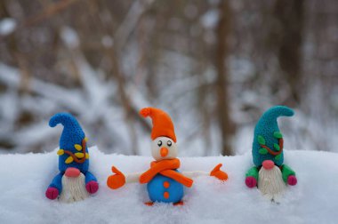 Kardan adam ve karlı ormanda bir cüce figürü. Yeni yıl havası..