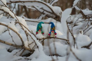 Karlı bir ormanda bir cüce figürü..