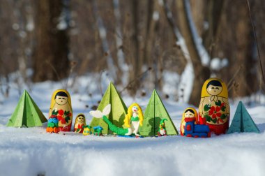 Karlı bir ormanda peri masalı karakterleri. Matrioshka, büyücü, deniz kızı, kağıt Noel ağacı ve cüce..