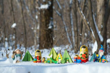 Karlı bir ormanda peri masalı karakterleri. Matrioshka, büyücü, deniz kızı, melek, kağıt Noel ağacı ve cüce..