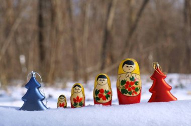 Kış ormanlarında bir sıra yuva kuran bebek ve oyuncak Noel ağaçları.