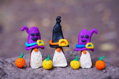 Şenlik şapkalı üç cüce figürü. Yakında balkabağı figürleri var..