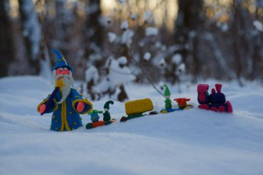 Kış ormanındaki bir büyücü figürü. Noel oyuncak treninin yanında..