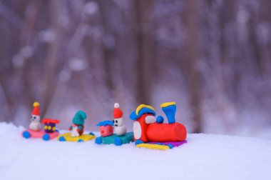Kar beyazı arka planında plastik oyuncaklar olan Noel treni..