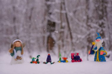 Kış ormanında oyuncaklarla dolu bir Noel treni. Yanında bir büyücü ve bir melek figürü var..