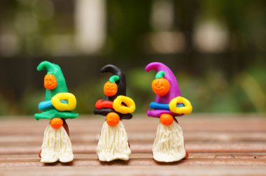 Bir şenlik şapkası ve balkabağıyla süslenmiş plastikten yapılmış üç cüce figürü. Cadılar Bayramı konsepti.