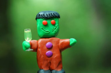 Bir bardak şampanyayla plastikten yapılmış komik bir canavar figürü. Cadılar Bayramı teması.