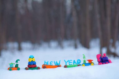 Oyuncak tren, kış ormanında plastikten yapılmış Noel oyuncaklarıyla dolu. Tatil dekorasyonları.
