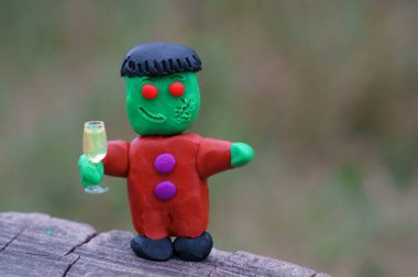 Bir bardak şampanyayla plastikten yapılmış komik bir canavar figürü. Cadılar Bayramı teması.