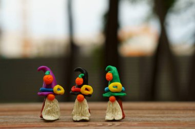 Bir şenlik şapkası ve balkabağıyla süslenmiş plastikten yapılmış üç cüce figürü. Cadılar Bayramı konsepti.
