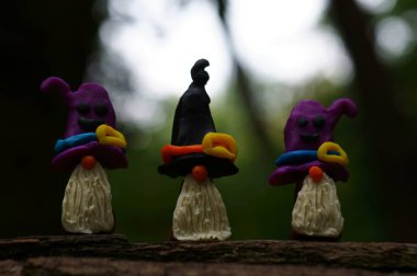 Karanlık bir arka planda üç cüce figürü.